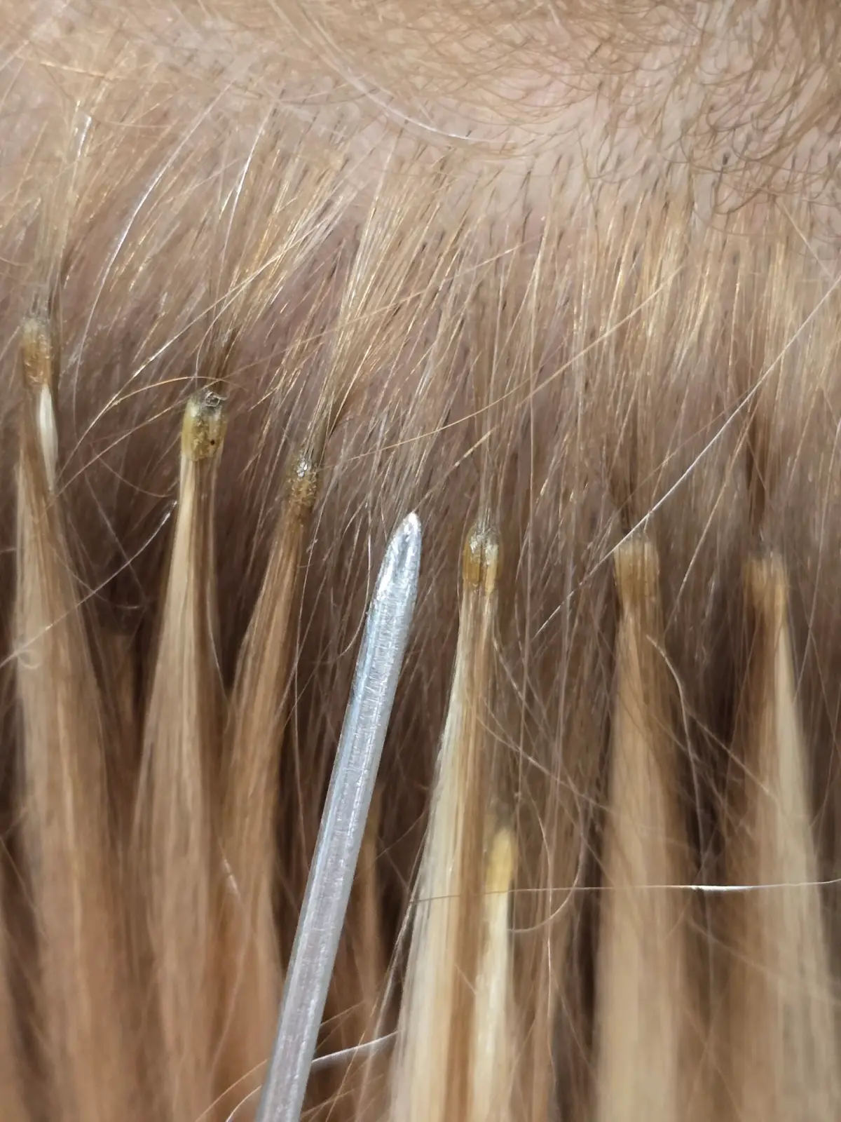 (clip-in) Zdjęcie przedstawiające doczepienie włosów do naturalnych włosów podczas przedłużania włosów